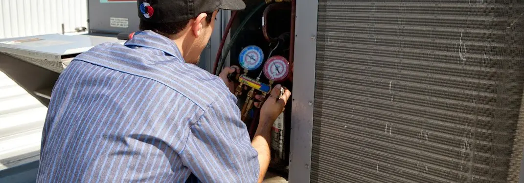 HVAC technician servicing a condenser unit in Tanglewilde