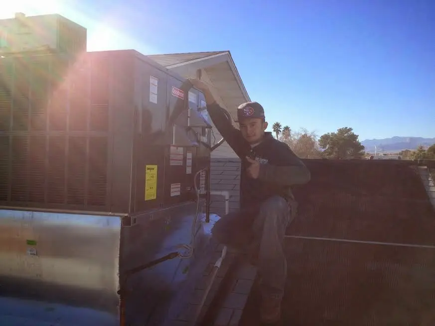 HVAC technician performing Boiler Repair on a rooftop unit in Tanglewilde